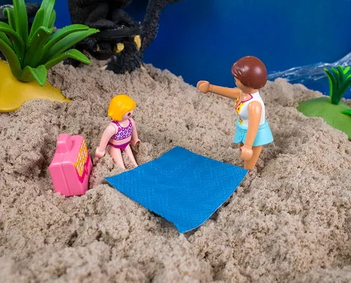 Afbeelding van twee speelgoed poppetjes naast een picknick kleed.